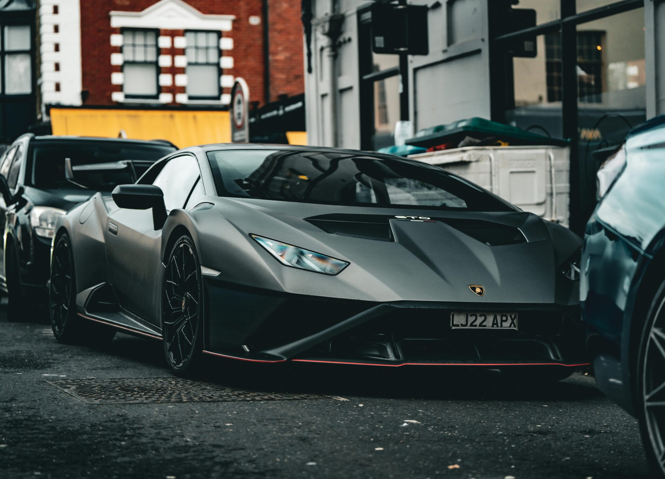 Matte black Lamborghini parked on a bustling street in Southampton, UK, showcasing urban luxury.