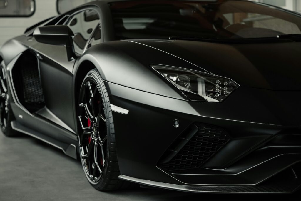 Close-up of a sleek black sports car, highlighting luxurious design and detail.